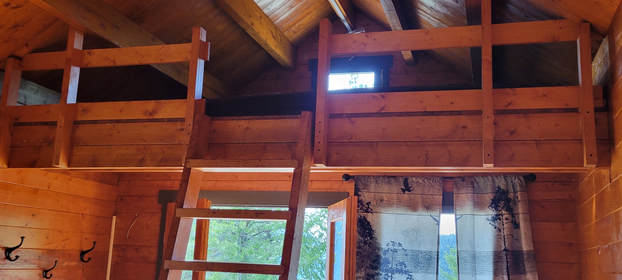 Sleeping loft and wooden ladder inside the Big Cat Ranch cabin
